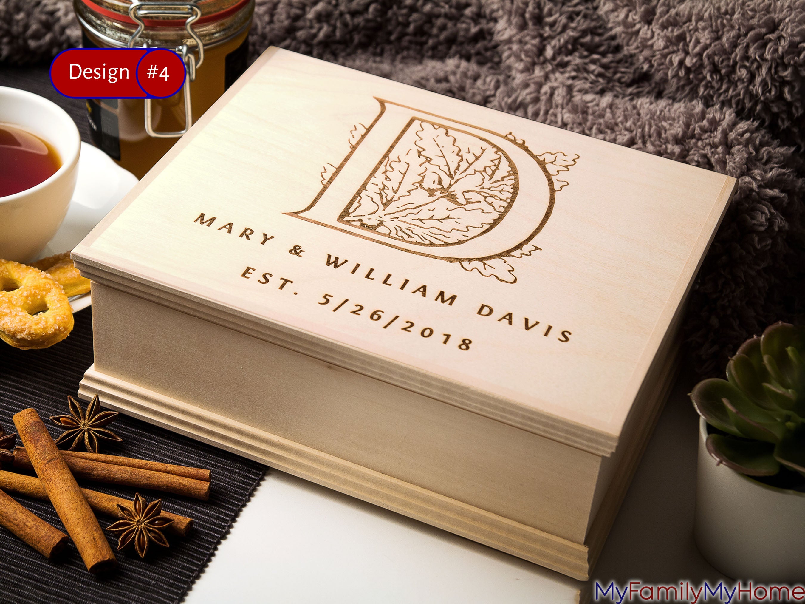Monogrammed wooden tea box with compartments featuring custom engraving of initial 'D', names, and date. Ideal for stylish tea storage and gifting.